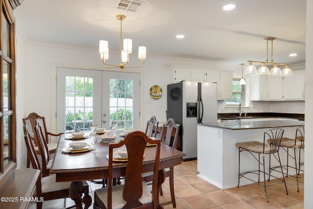 dining space featuring light tile patterned floors, a notable chandelier, french doors, crown molding, and sink