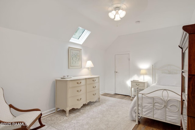 bedroom featuring light wood-type flooring, ceiling fan, and lofted ceiling with skylight