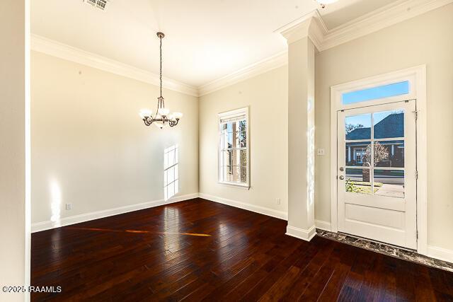 entrance foyer featuring crown molding, hardwood / wood-style flooring, and an inviting chandelier