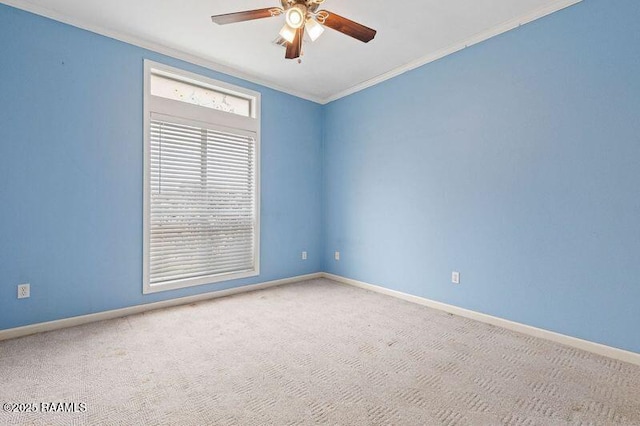 carpeted spare room featuring crown molding and ceiling fan