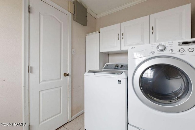 clothes washing area with cabinets, crown molding, washer and dryer, and light tile patterned floors