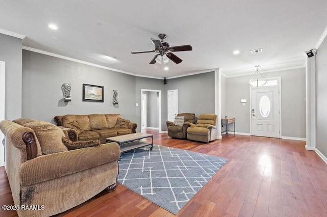 living room with hardwood / wood-style flooring, crown molding, and ceiling fan