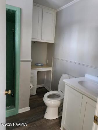 bathroom with a shower, hardwood / wood-style floors, vanity, and toilet