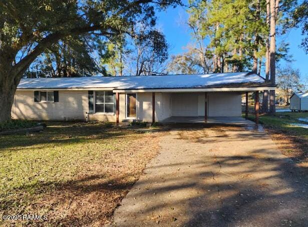 ranch-style house with a front yard and a carport