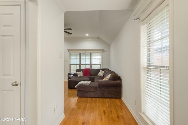 living room featuring ceiling fan, lofted ceiling, and light hardwood / wood-style flooring