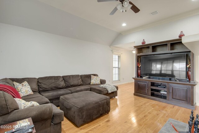 living room with light wood-type flooring, ceiling fan, and vaulted ceiling