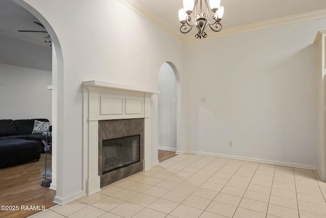 tiled living room with ornamental molding, a notable chandelier, and a fireplace