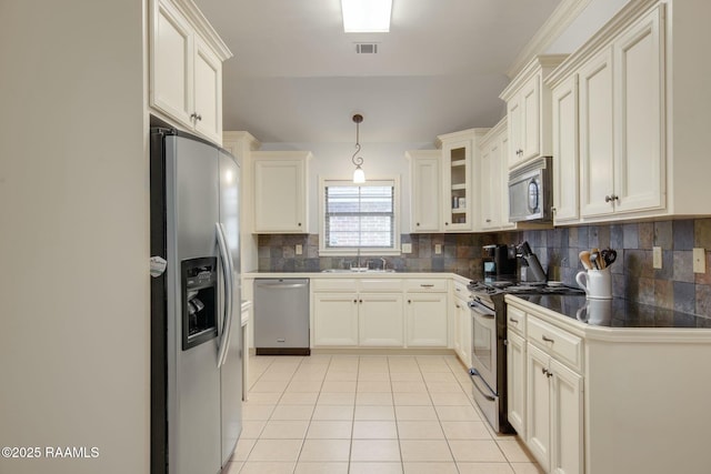 kitchen featuring light tile patterned flooring, appliances with stainless steel finishes, backsplash, and sink