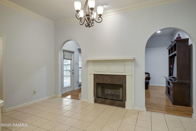 unfurnished living room with an inviting chandelier, light tile patterned floors, ornamental molding, and a fireplace