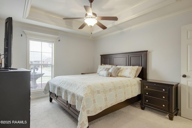 bedroom featuring light carpet, ceiling fan, crown molding, and a tray ceiling