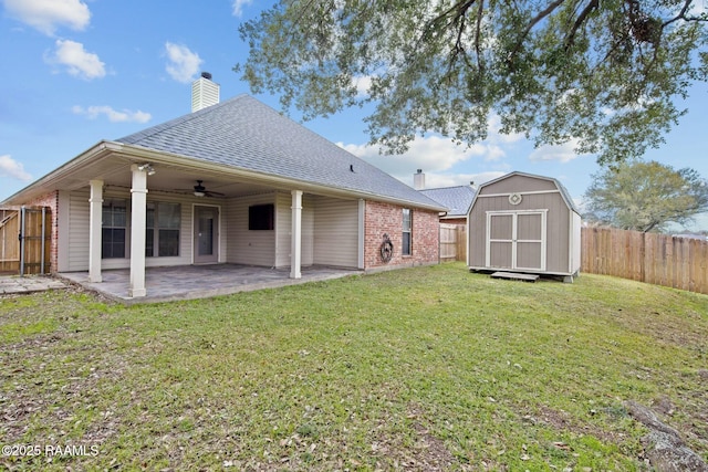 rear view of house with a yard, a storage unit, and a patio