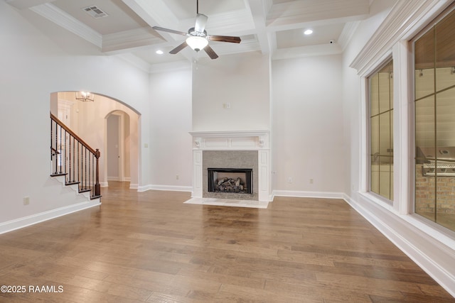 unfurnished living room with beamed ceiling, light hardwood / wood-style floors, ceiling fan, crown molding, and coffered ceiling