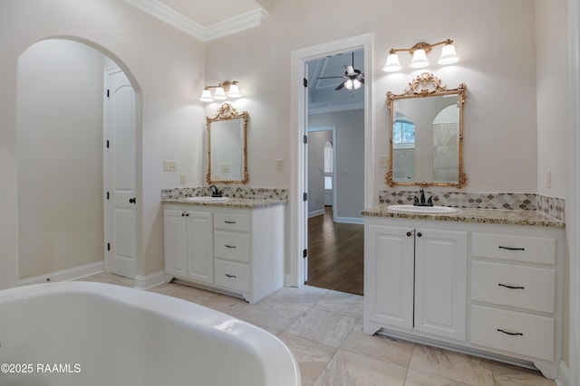 bathroom with vanity, decorative backsplash, a washtub, and ornamental molding