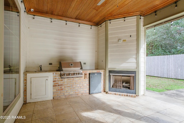 view of patio featuring an outdoor fireplace, an outdoor kitchen, a grill, and sink