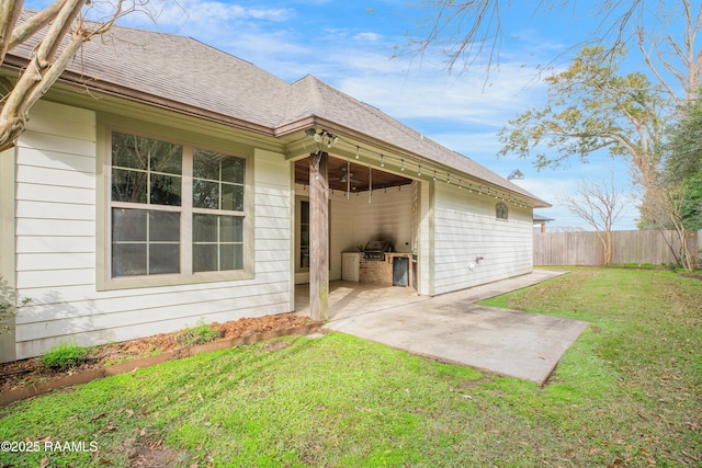 rear view of property with a patio area, a yard, and area for grilling