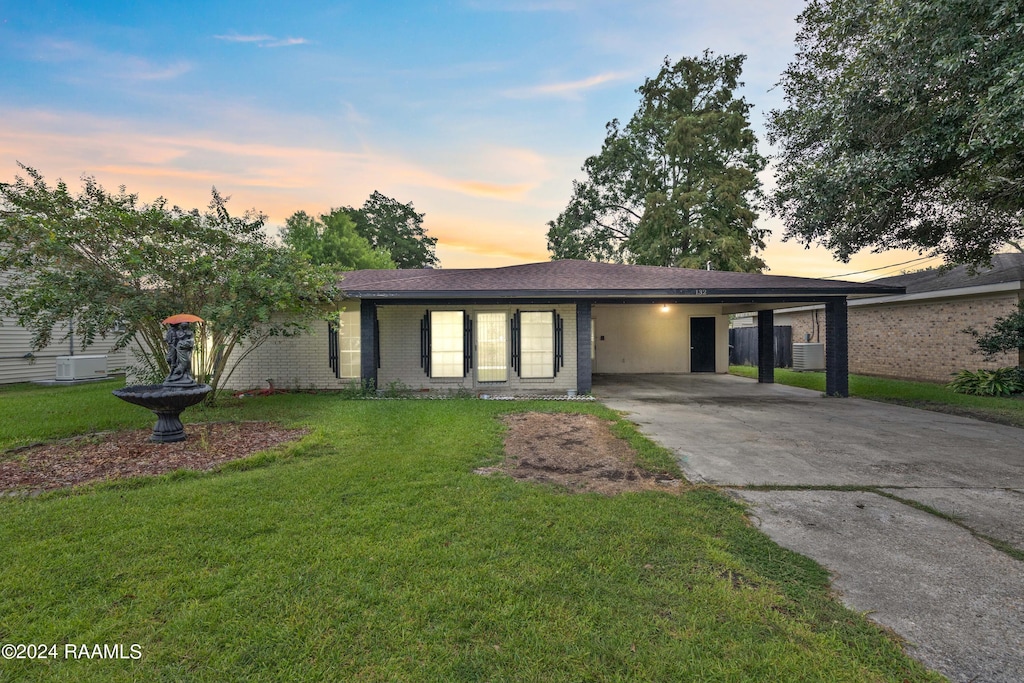 single story home featuring a lawn and a carport