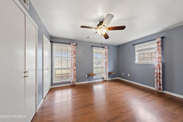 spare room featuring plenty of natural light, dark wood-type flooring, and ceiling fan