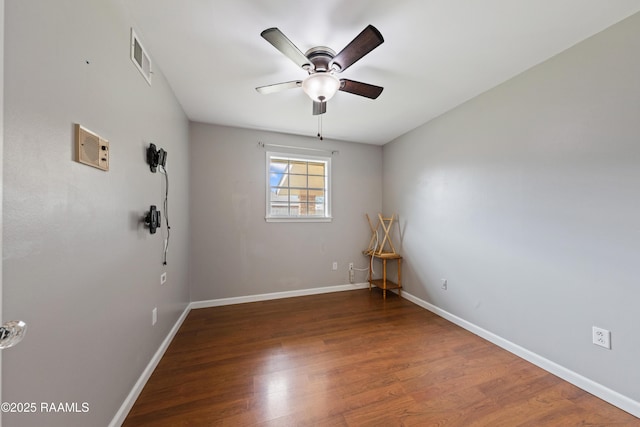 spare room with dark wood-type flooring and ceiling fan