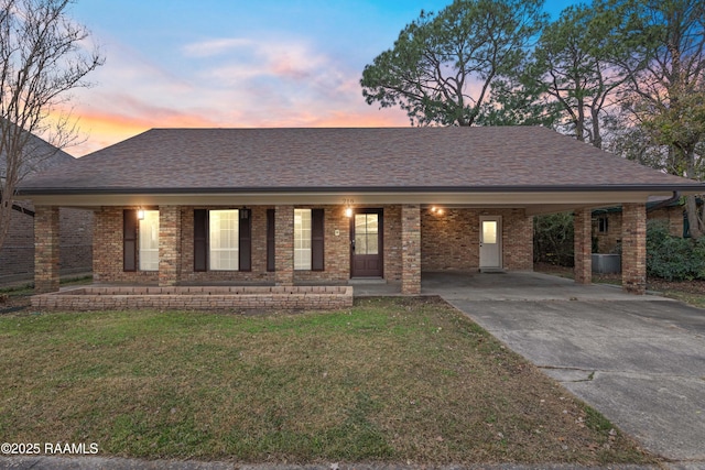 ranch-style home with a lawn and a carport