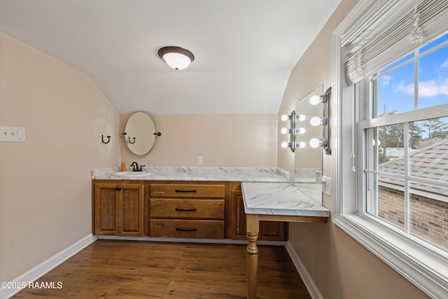 bathroom with hardwood / wood-style floors, vanity, and vaulted ceiling