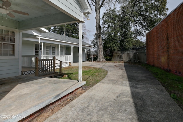 view of yard with ceiling fan and covered porch