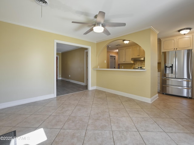 kitchen featuring ornamental molding, light tile patterned floors, tasteful backsplash, and stainless steel fridge