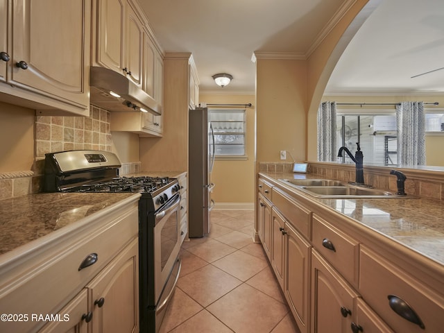 kitchen featuring light brown cabinetry, appliances with stainless steel finishes, sink, light tile patterned flooring, and ornamental molding