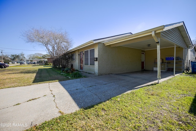 view of side of property featuring a lawn and a carport