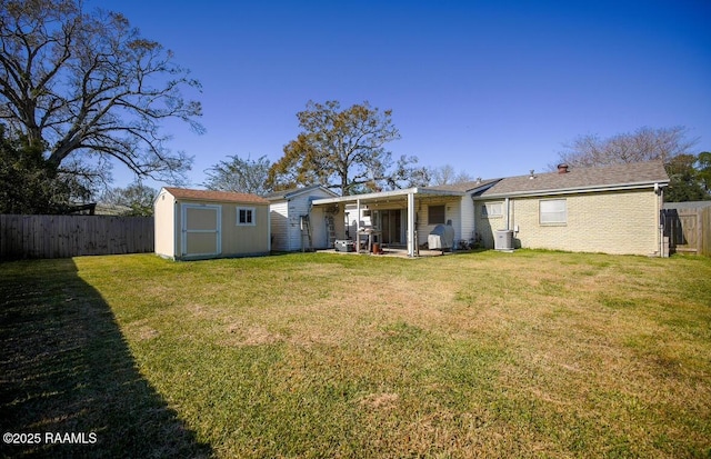 rear view of house with a lawn, central AC, and a shed