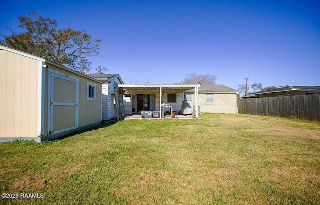 rear view of house featuring a yard and a storage shed