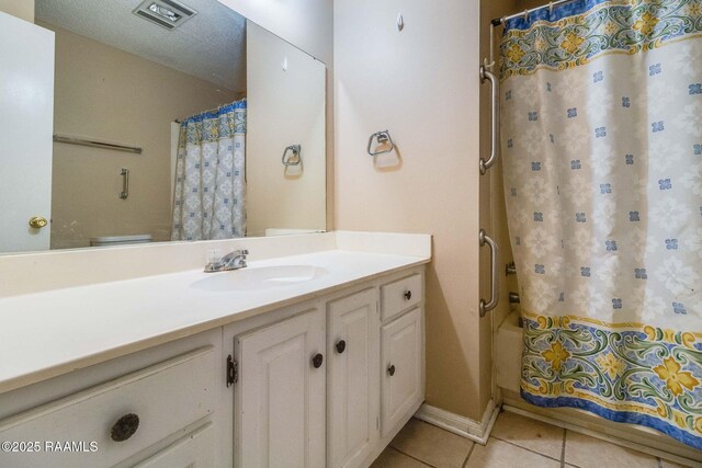 bathroom featuring vanity, tile patterned floors, and a textured ceiling