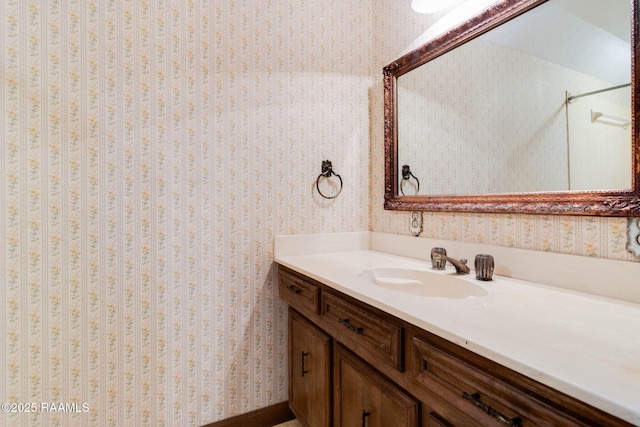 bathroom featuring vanity and wallpapered walls