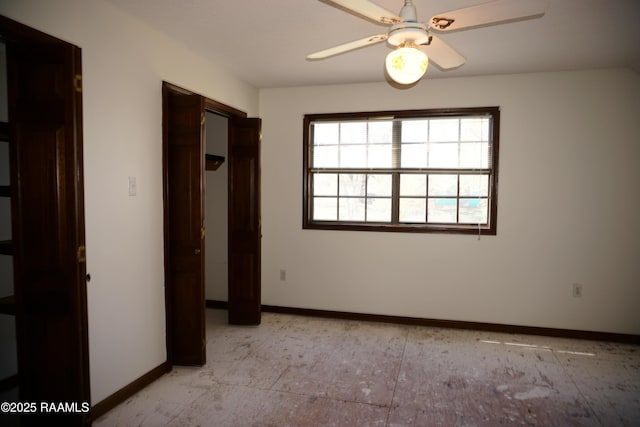 unfurnished bedroom with a ceiling fan and baseboards