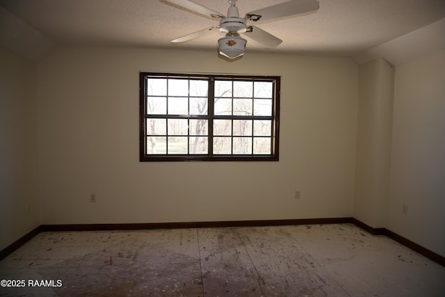 spare room with baseboards, a textured ceiling, a ceiling fan, and vaulted ceiling