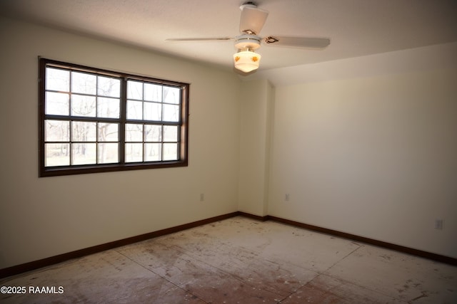 empty room with a ceiling fan and baseboards