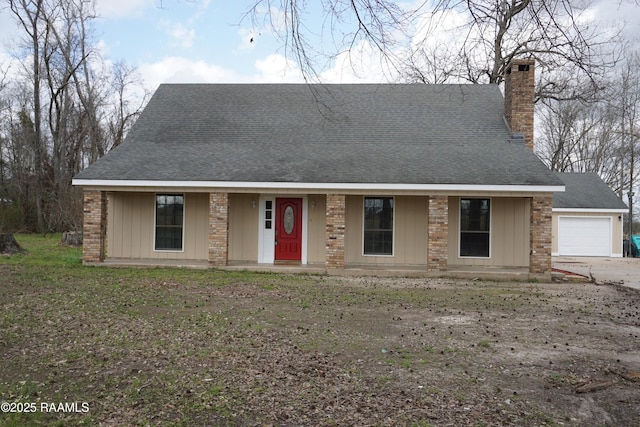 view of front of property with a garage, board and batten siding, a chimney, and a shingled roof