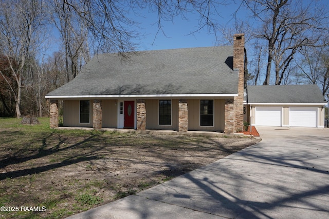 view of front of home with an attached garage, a chimney, driveway, and a shingled roof