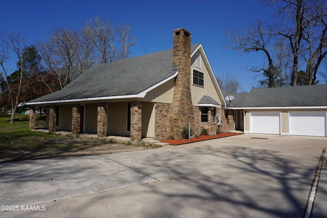 view of front facade featuring concrete driveway, an attached garage, a shingled roof, brick siding, and a chimney