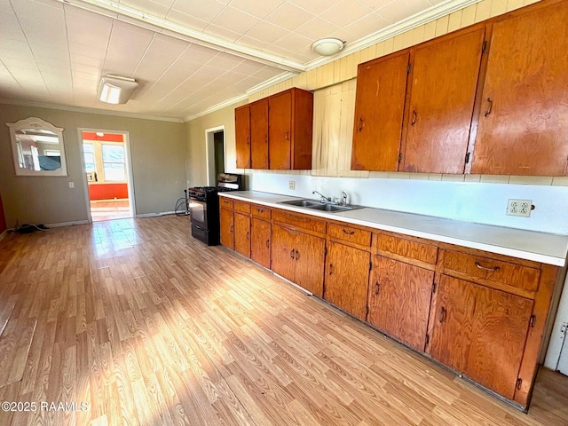 kitchen featuring black range with gas cooktop, sink, crown molding, and light hardwood / wood-style floors