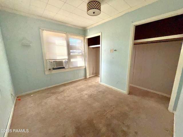 unfurnished bedroom with cooling unit, crown molding, light colored carpet, and a closet