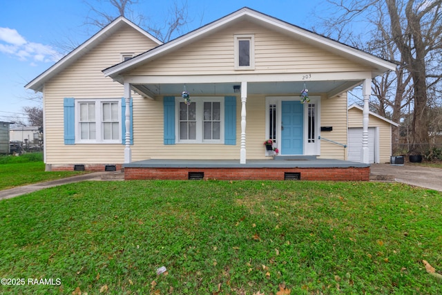 bungalow-style house with a garage, an outdoor structure, covered porch, and a front yard