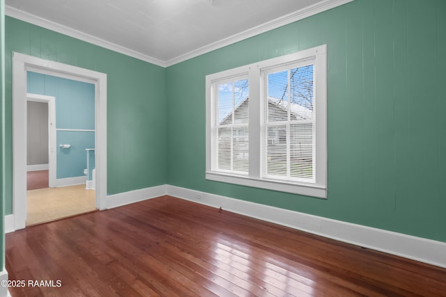 spare room with hardwood / wood-style flooring and crown molding