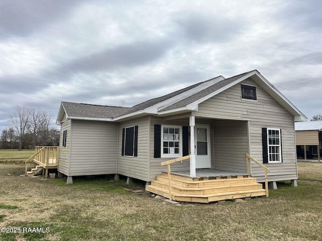 rear view of house featuring a yard