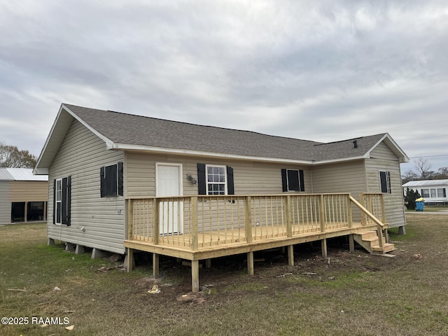 back of house with a deck and a lawn