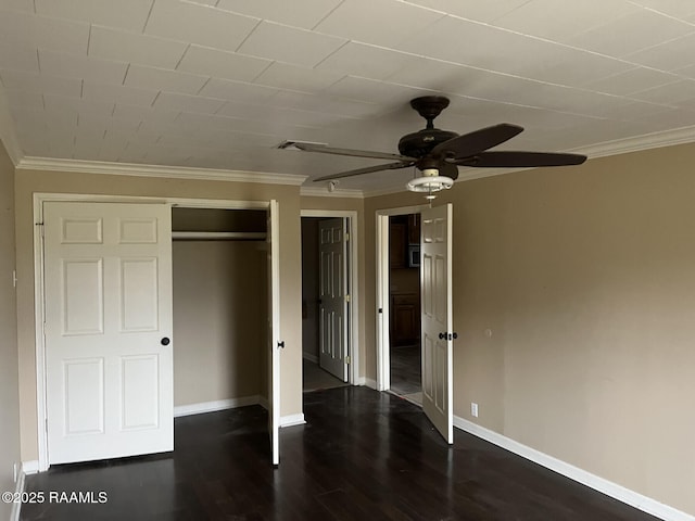 unfurnished bedroom with ornamental molding, dark hardwood / wood-style floors, ceiling fan, and a closet