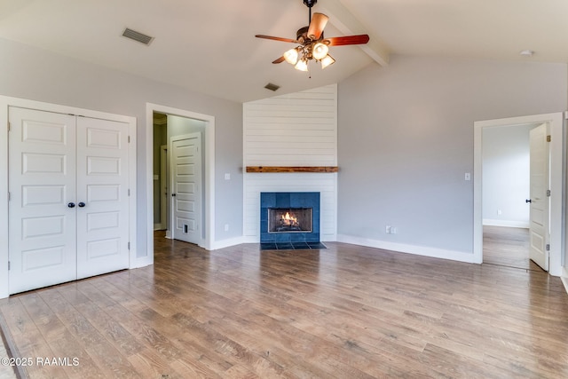 unfurnished living room featuring lofted ceiling with beams, wood-type flooring, a fireplace, and ceiling fan