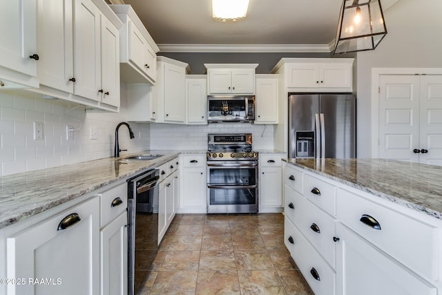 kitchen featuring decorative light fixtures, tasteful backsplash, sink, white cabinets, and stainless steel appliances