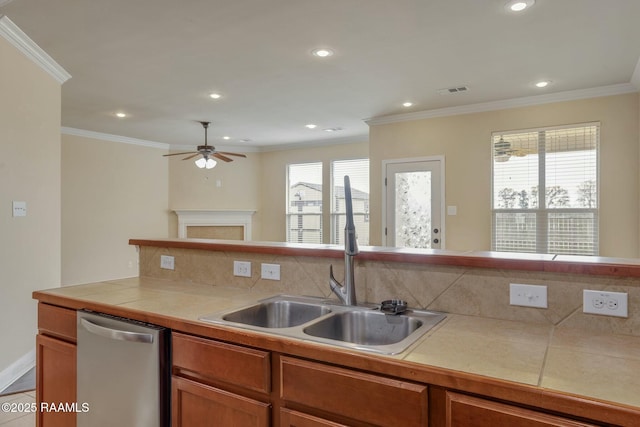 kitchen with sink, crown molding, light tile patterned floors, stainless steel dishwasher, and tile counters