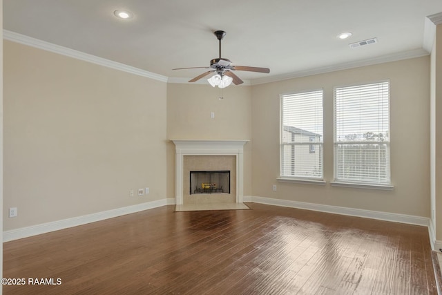 unfurnished living room with ceiling fan, ornamental molding, a premium fireplace, and wood-type flooring