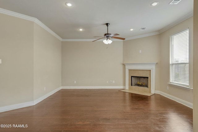 unfurnished living room with ceiling fan, crown molding, a high end fireplace, and dark wood-type flooring